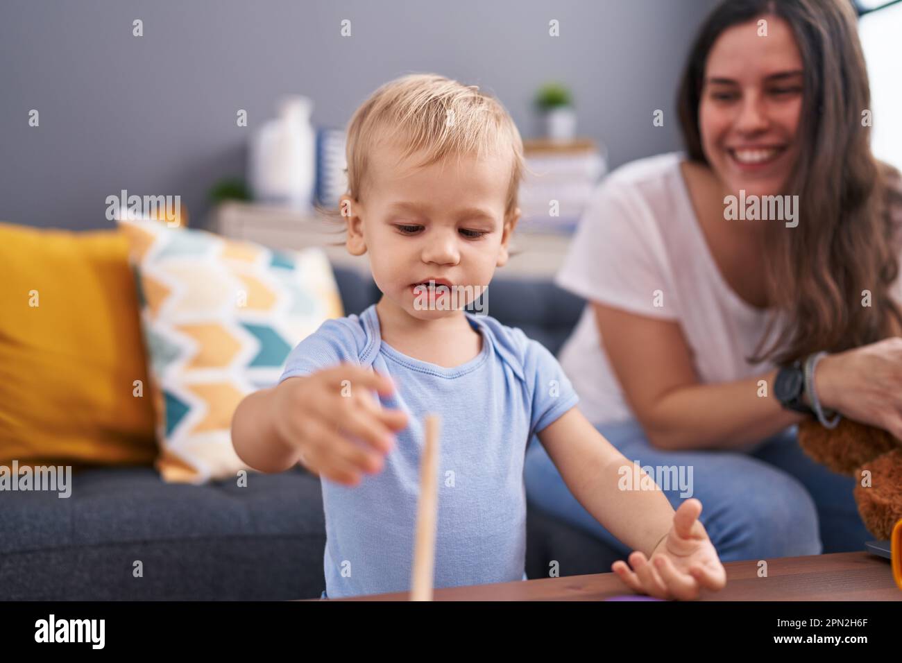 Mother and son holding teddy bear playing at home Stock Photo - Alamy