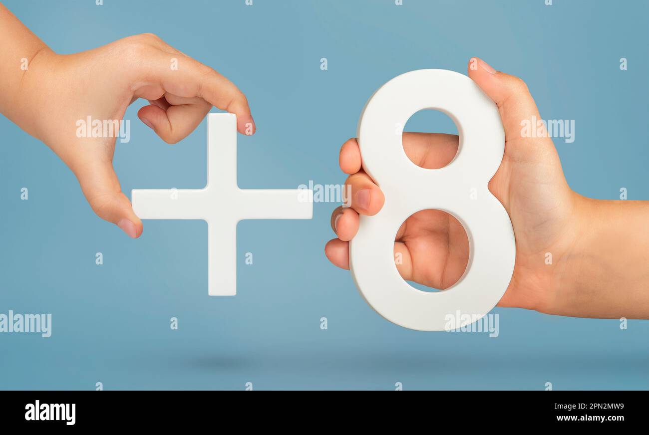 The number eight and the plus symbol in the hands of a child on a blue ...