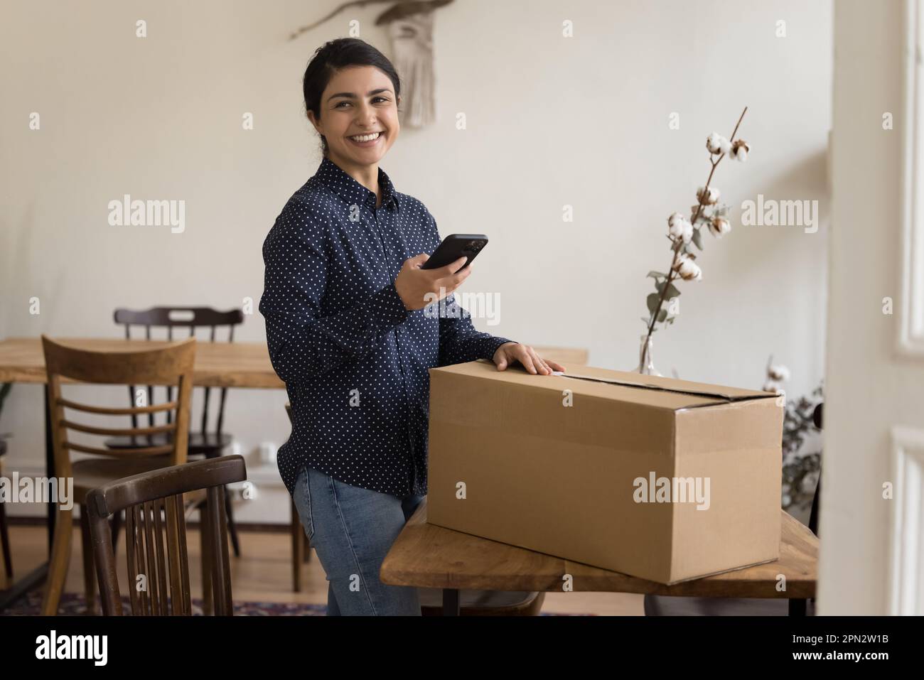 Satisfied Indian woman sending parcel using courier on-line services Stock Photo