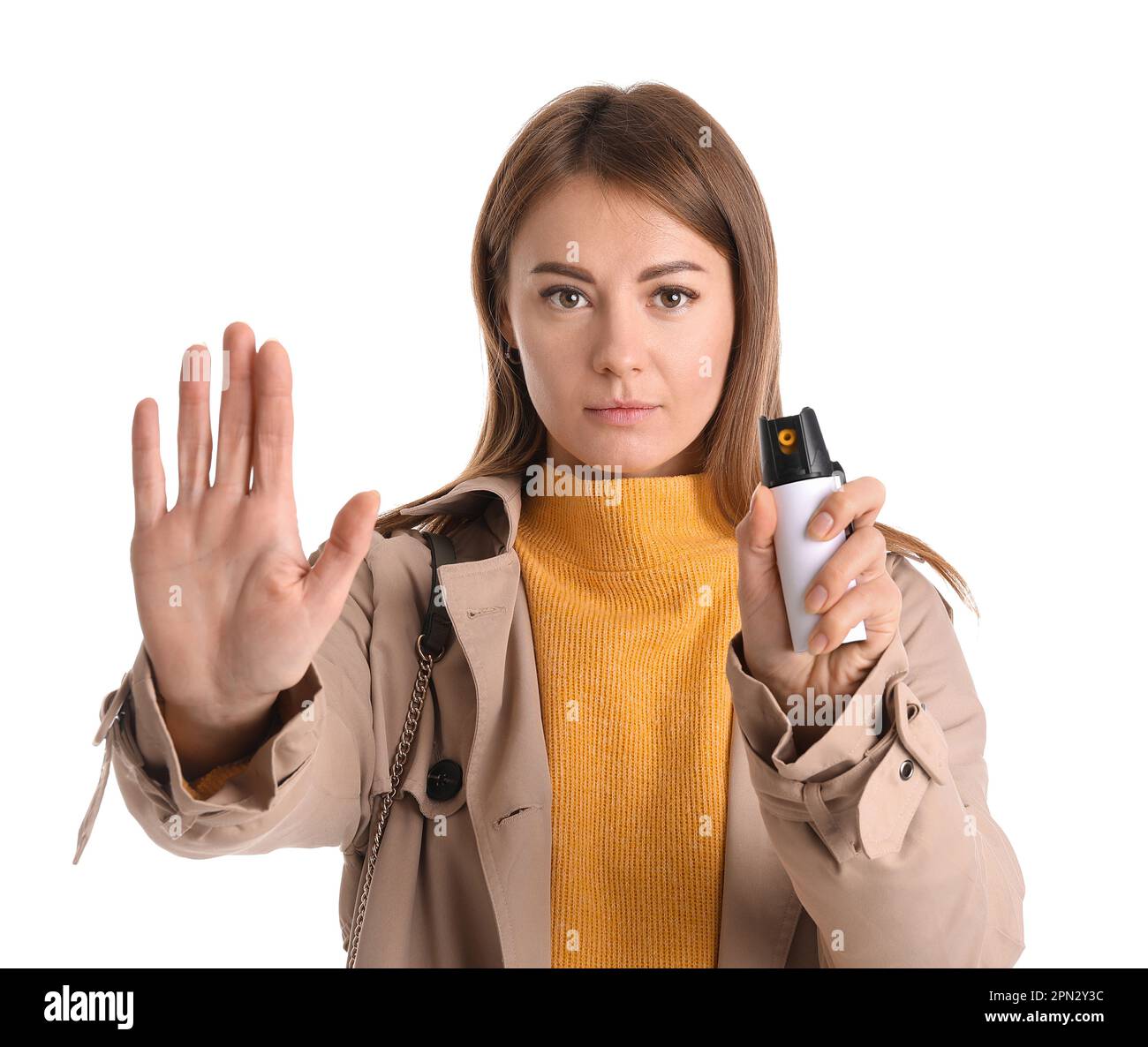 Young woman with pepper spray for selfdefence showing STOP gesture on
