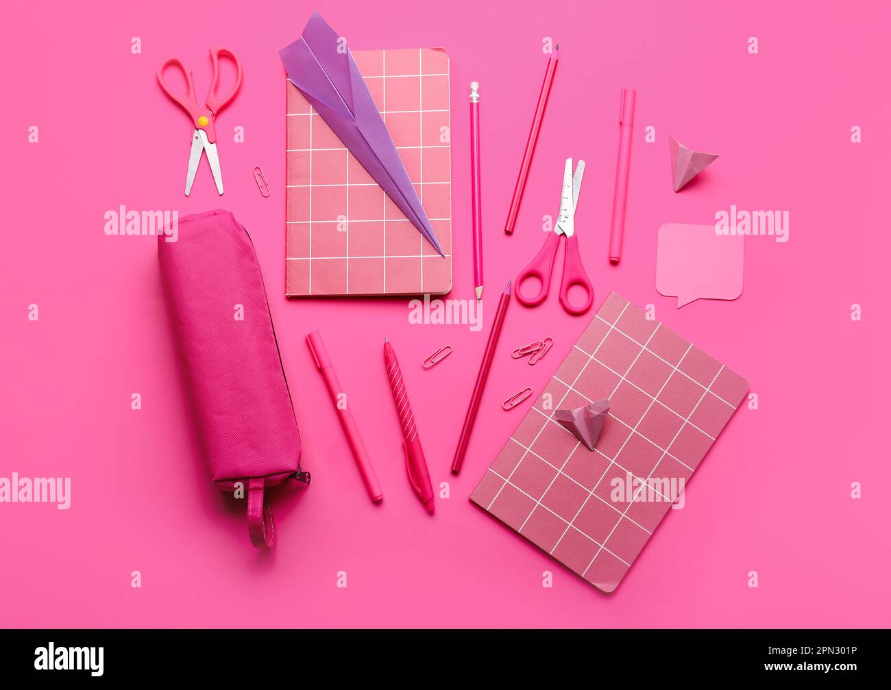 Composition with stationery supplies and paper planes on pink ...