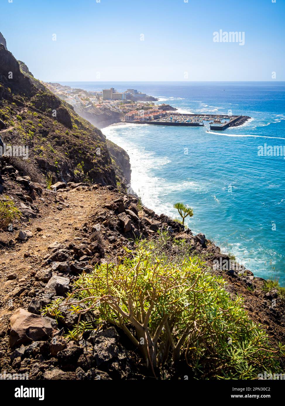 Capture the thrill as a narrow and perilous trail winds along the towering Acantilados de Los Gigantes cliffs. Stock Photo