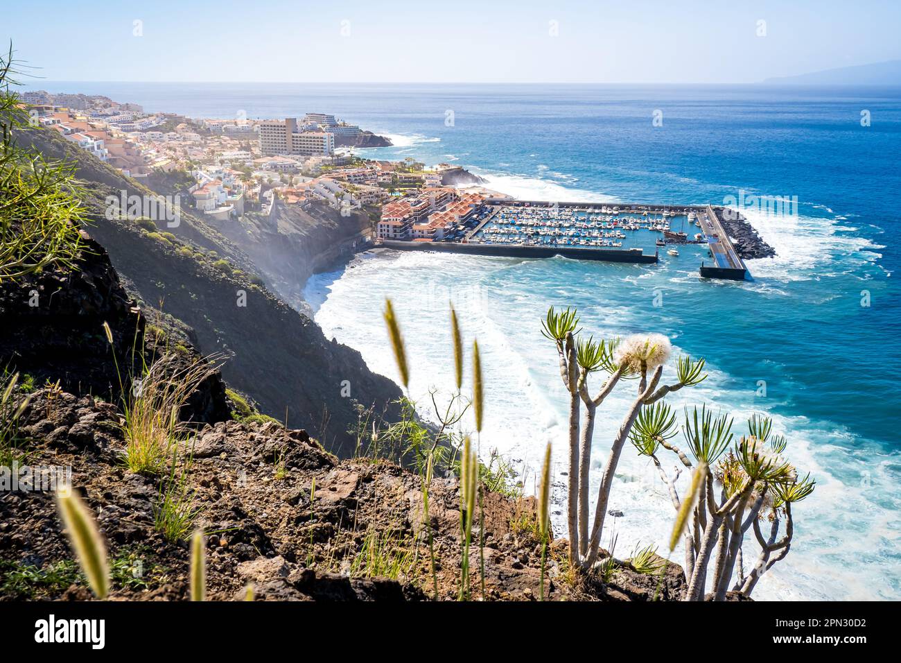 Panoramic view from a towering cliff showcases Los Gigantes village, Puerto de Los Gigantes harbor and Playa Los Guíos beach. Stock Photo
