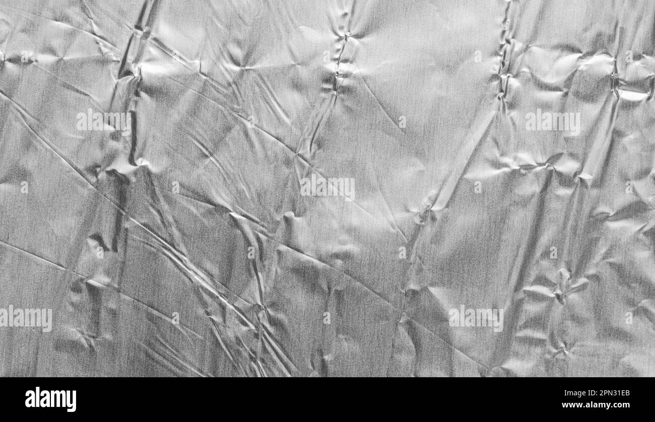 Crumpled bright shiny metallic silver aluminium foil background, flat