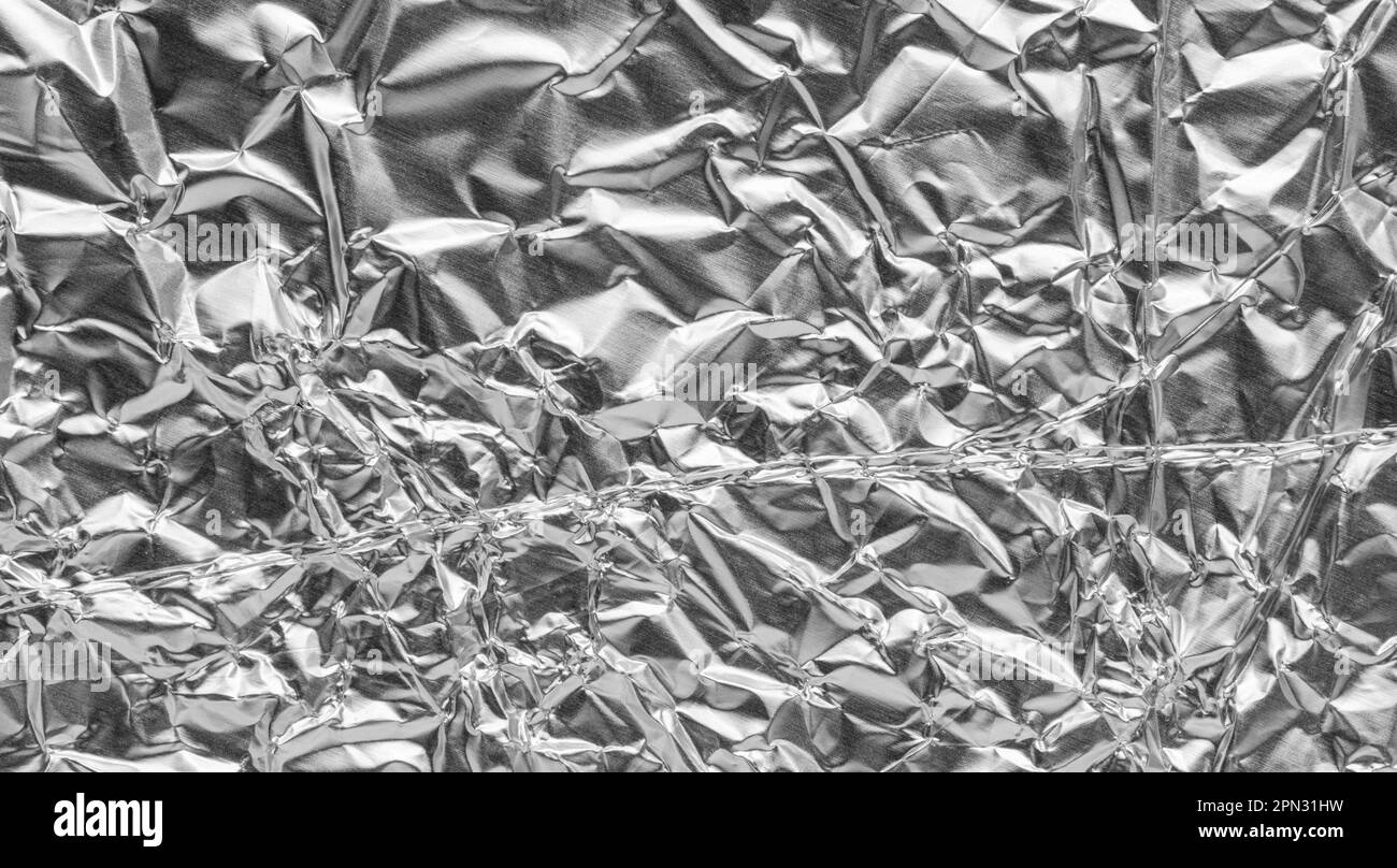 Crumpled bright shiny metallic silver aluminium foil background, flat