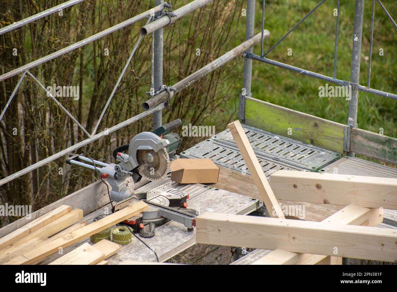 Multi material saw from carpenter on construction railing of a new wooden roof with rafter Stock Photo