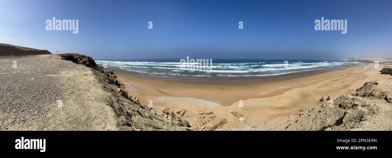 Morocco: view of Atlantic Ocean near Essaouira with some mule-driven workers crossing a beach to go and collect molluscs and shellfish from mussels Stock Photo