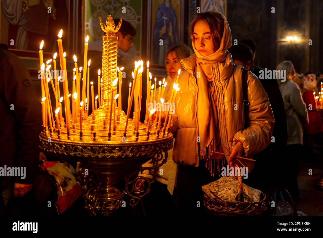 Ukrainian believers burn candles during the Holy Saturday celebrations in St. Michael's Golden-Domed Monastery in central Kyiv, the capital of Ukraine on April 16, 2023. According to the tradition the faithful bring their Easter food in a basket to be purified, it always is Pasha (Easter bread), painted egg (pysanka) among other. Most of Ukrainians are Orthodox Christians or Greek Catholic Christians, both observe the eastern rite of Easter. Kyiv remains relatively peaceful as the Russian invasion continuous and Ukraine prepares for a spring counter-offensive to retake Ukrainian land occupied Stock Photo