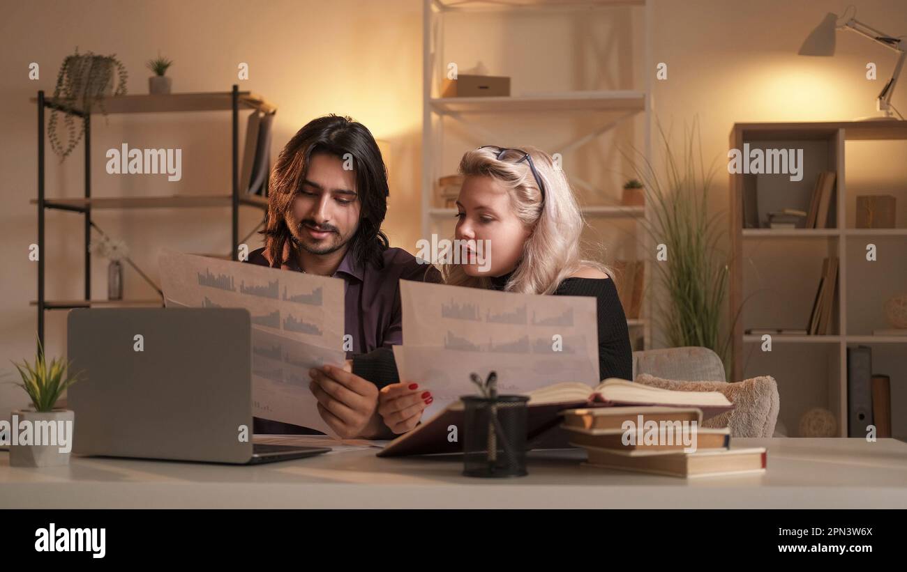 Couple study learning economics charts graphs home Stock Photo