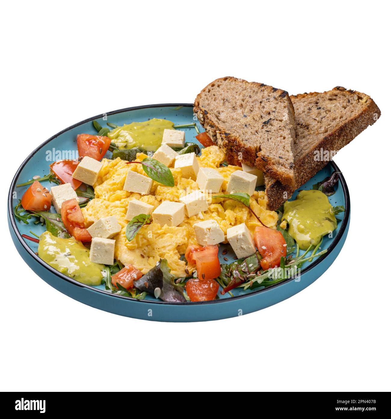 Restaurant breakfast menu concept, scrambled eggs with tofu, tomatoes and guacamole Stock Photo