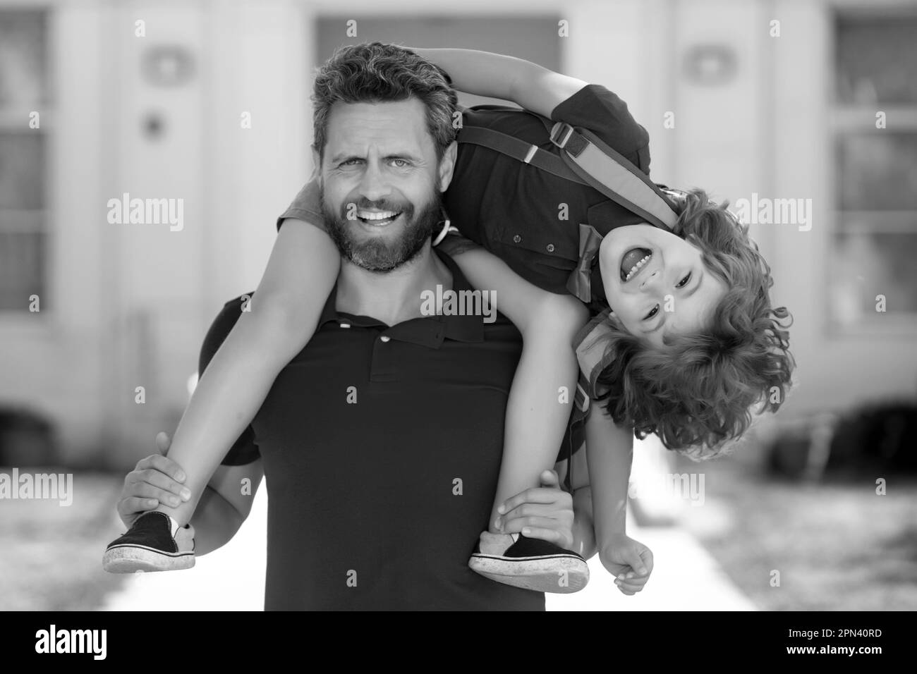 Parent supports and motivates son. Father giving son piggyback ride