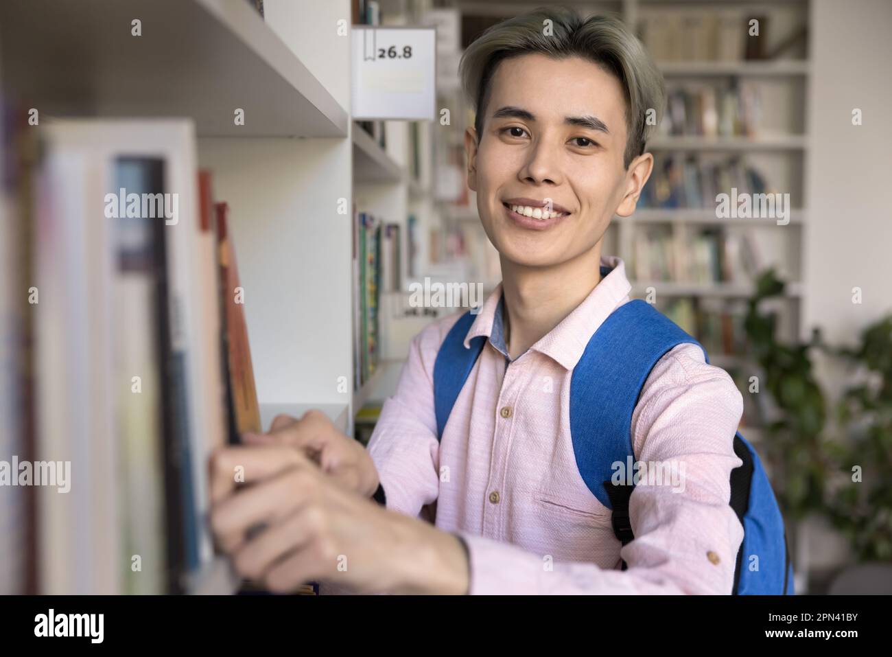 Library Guy Student guy search book standing in library look at camera Stock Photo ...