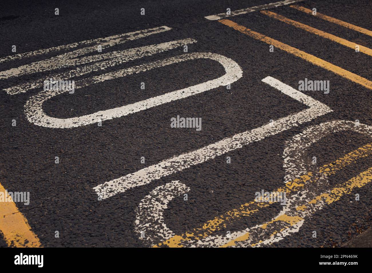 Slow sign written on the asphalt to warn drivers to lower the speed Stock Photo