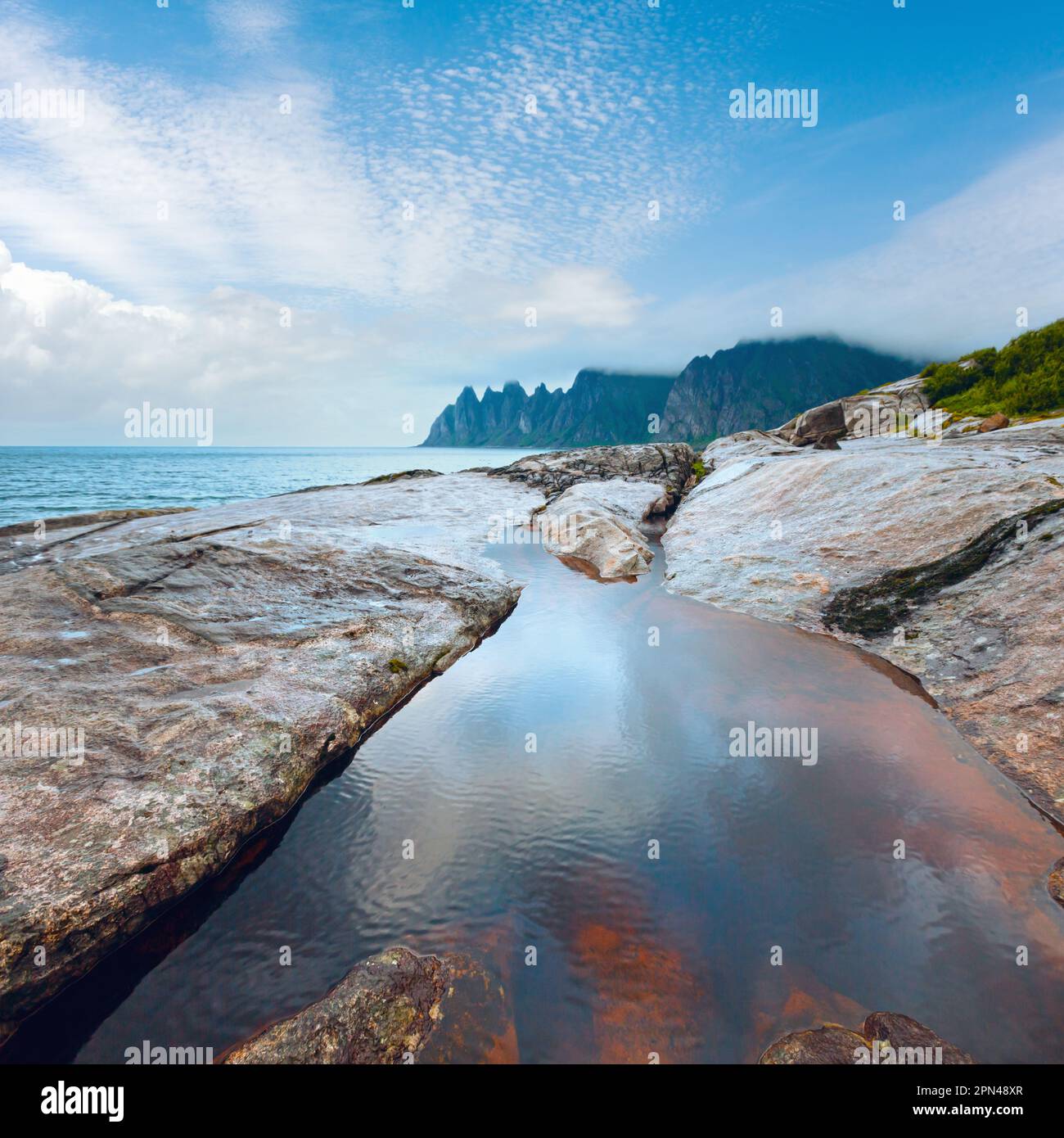 Summer night coast. The dragon's teeth rock, Jagged Ersfjord, Senja, Norway . Stock Photo