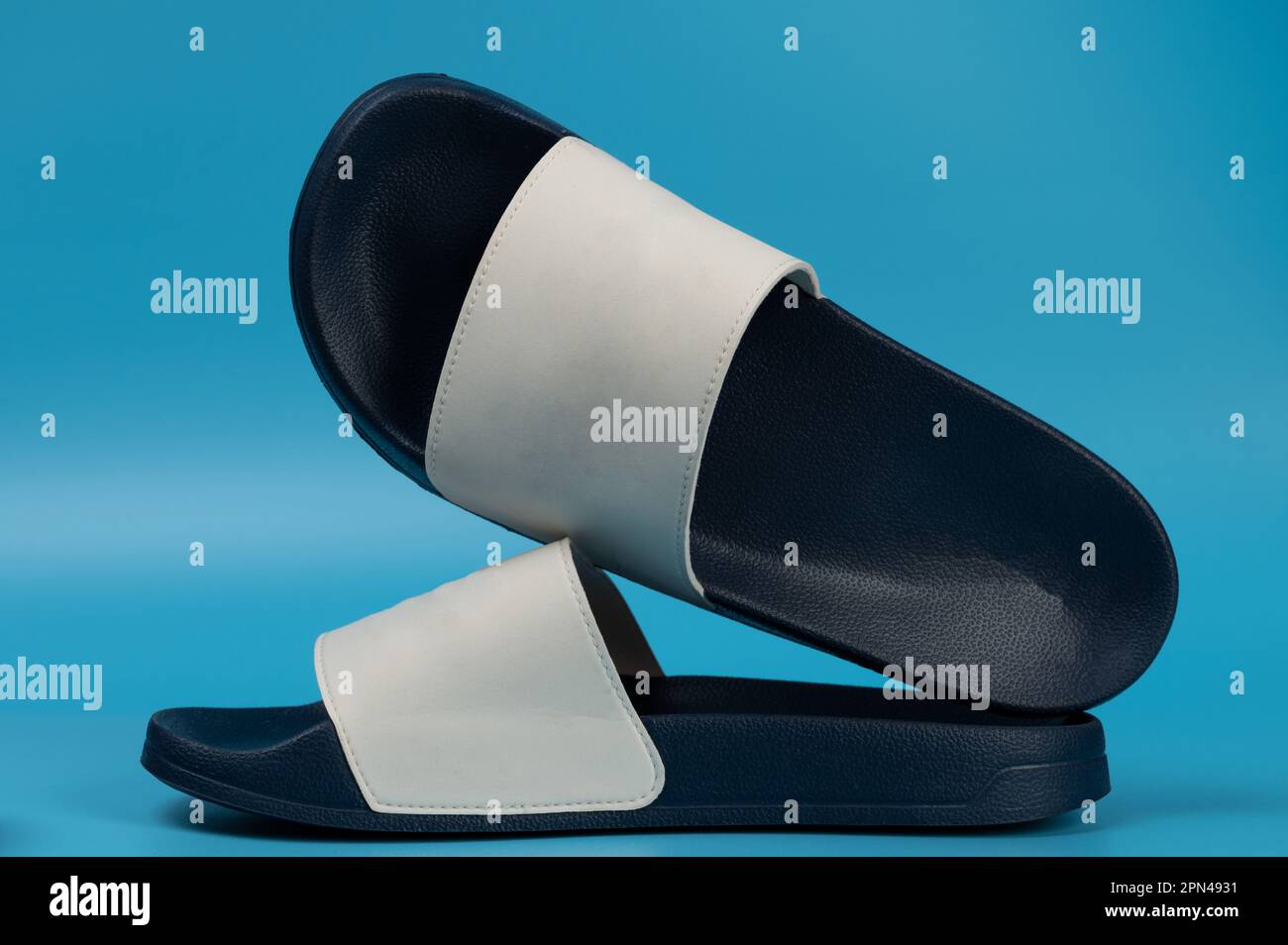 Dark blue and white flip flops on stduio background Stock Photo - Alamy