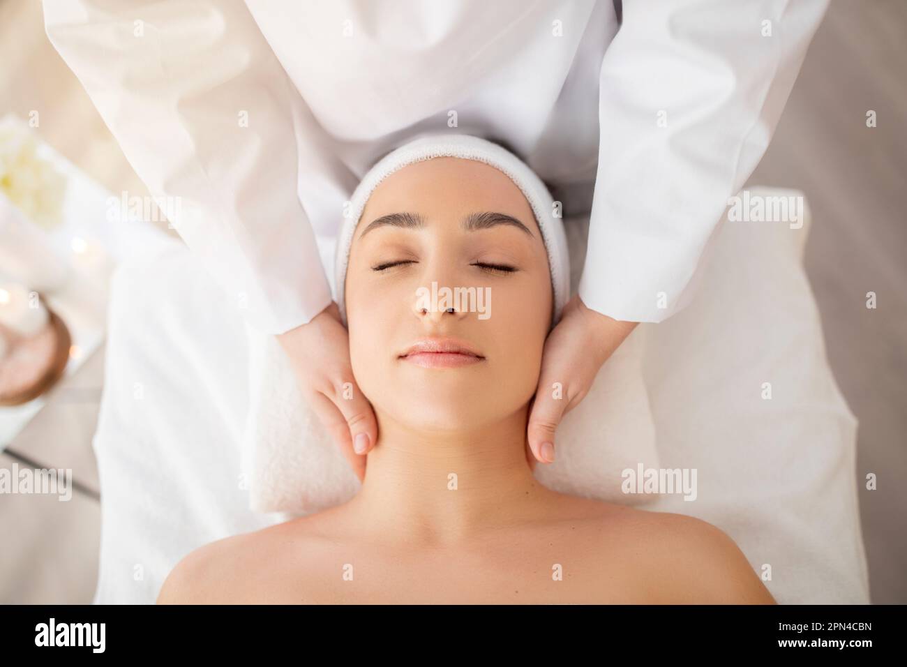 Young indian woman enjoying face lifting massage, top view Stock Photo