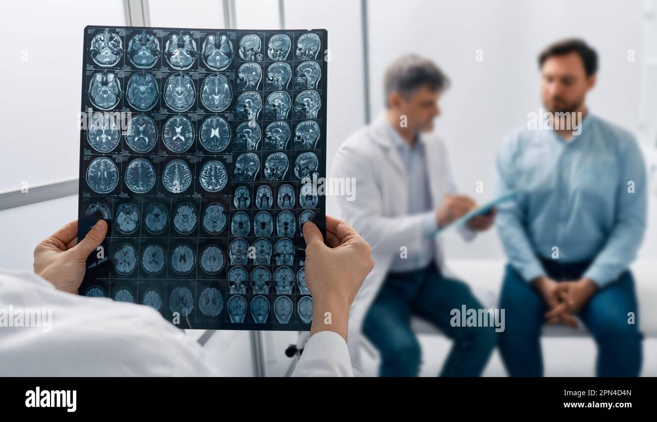 Male patient with headaches and migraines underwent MRI of brain and is consulting with hospital neurologist doctor. Headache treatment Stock Photo