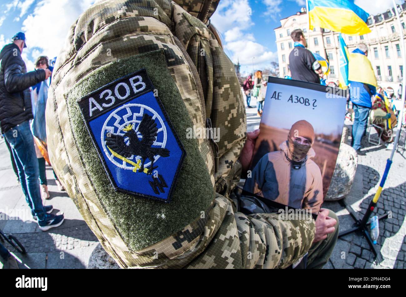Munich, Bavaria, Germany. 25th Mar, 2023. A demonstrator in Munich, Germany wears patches of the former Azov Battalion after holding a speech about the Azovstal defenders of Mariupol, some of whom are still in Russian captivity. The former Azov Battalion was converted to the Azov Regiment and the highly taboo Wolfsangel displayed here was changed and forbidden. Such displays in Germany are currently isolated incidents and there is currently no evidence of neonazi influence at the demos. Many who demonstrate for the plight of the Azovstal defenders conflate them with the Azov Regiment who were Stock Photo