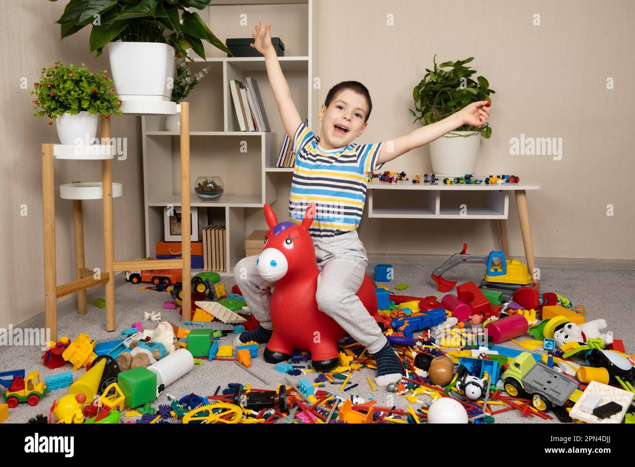 A little boy is jumping on an inflatable rubber donkey among the