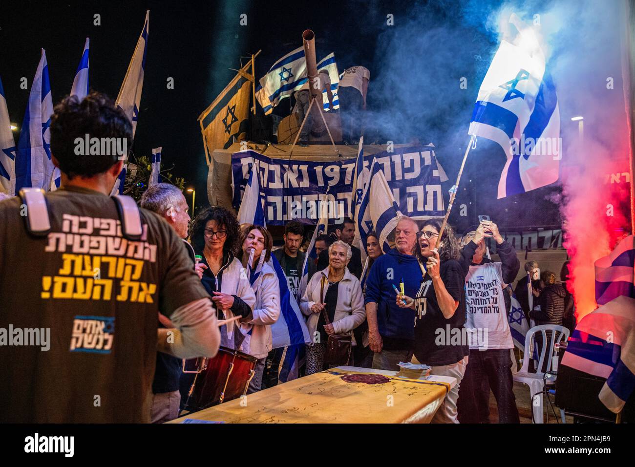 Israel. 15th Apr, 2023. Protestors against the reform sign a giant copy of the Israeli Declaration of Independence next to a tank model brought by the warriors of the 73' Yom Kippur War in a protestation against the legal overhaul in Netanya. Apr 15th 2023. (Matan Golan/Sipa USA). Credit: Sipa USA/Alamy Live News Stock Photo