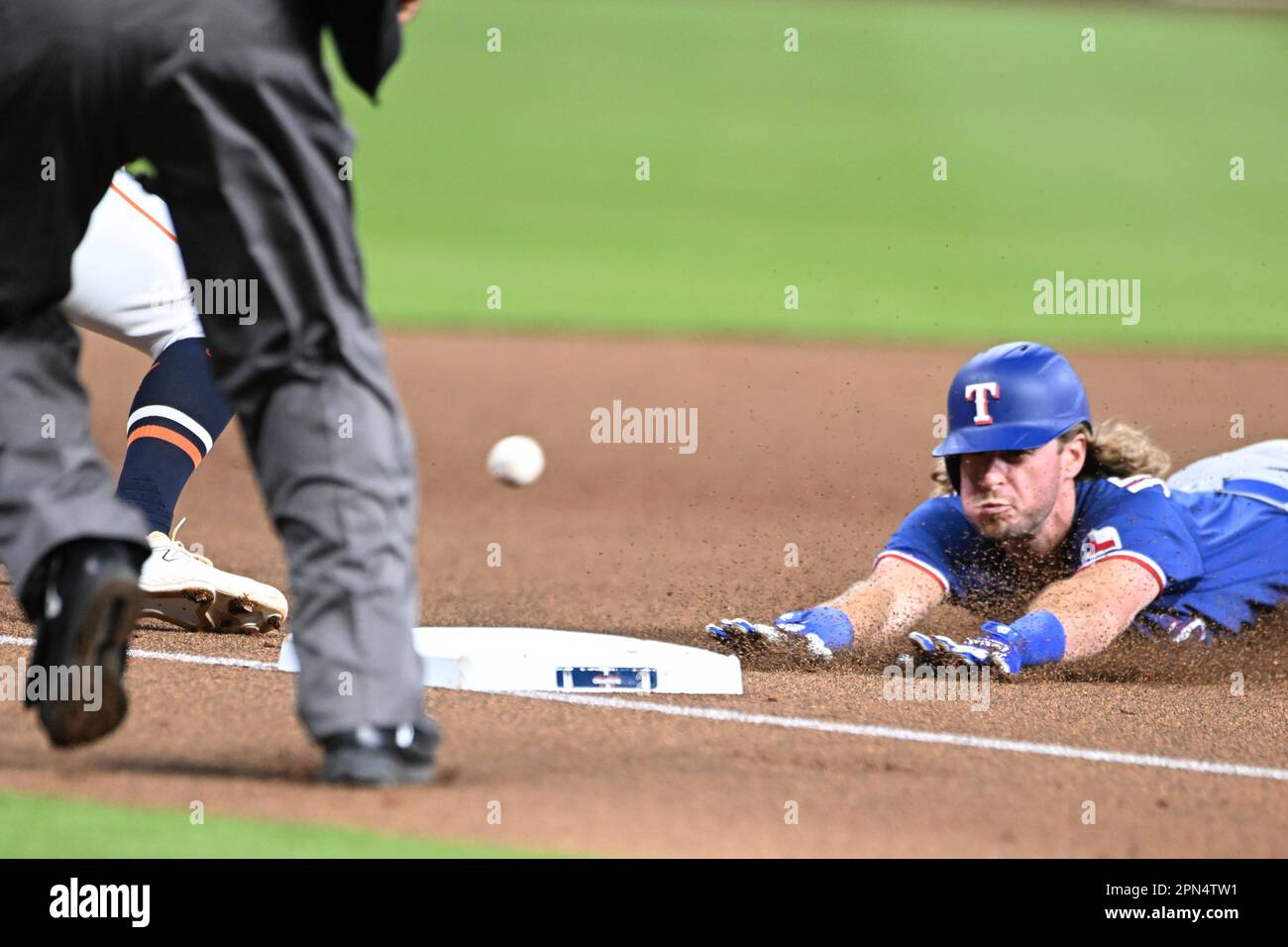 Texas Rangers left fielder Travis Jankowski (16) is safe on a head-first slide hitting a triple during the MLB game between the Texas Ranges and the H Stock Photo