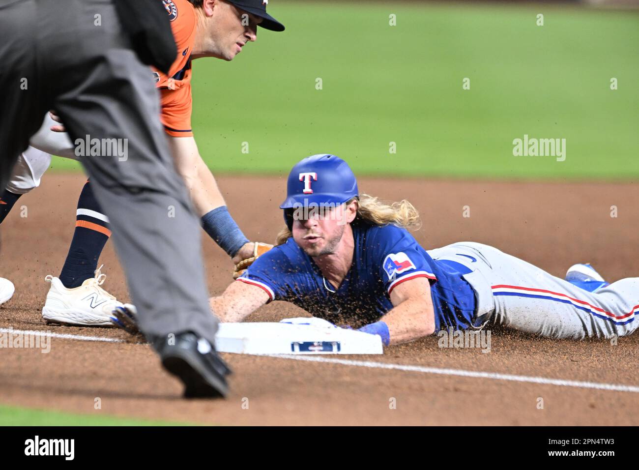 Texas Rangers left fielder Travis Jankowski (16) is safe on a head-first slide hitting a triple during the MLB game between the Texas Ranges and the H Stock Photo