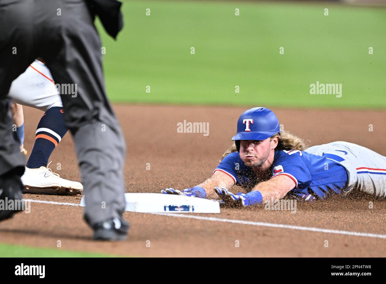 Texas Rangers left fielder Travis Jankowski (16) is safe on a head-first slide hitting a triple during the MLB game between the Texas Ranges and the H Stock Photo