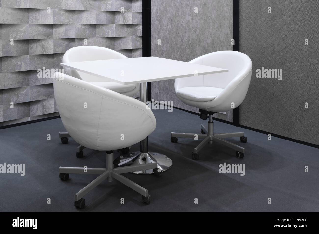 White chairs armchairs and a table in a meeting room Stock Photo