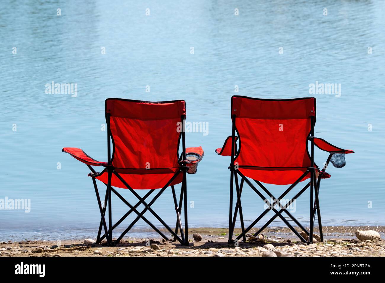 Outdoor detail, painted folding chair with canvas seat, set outside a beach  hut, fishing nets Stock Photo - Alamy