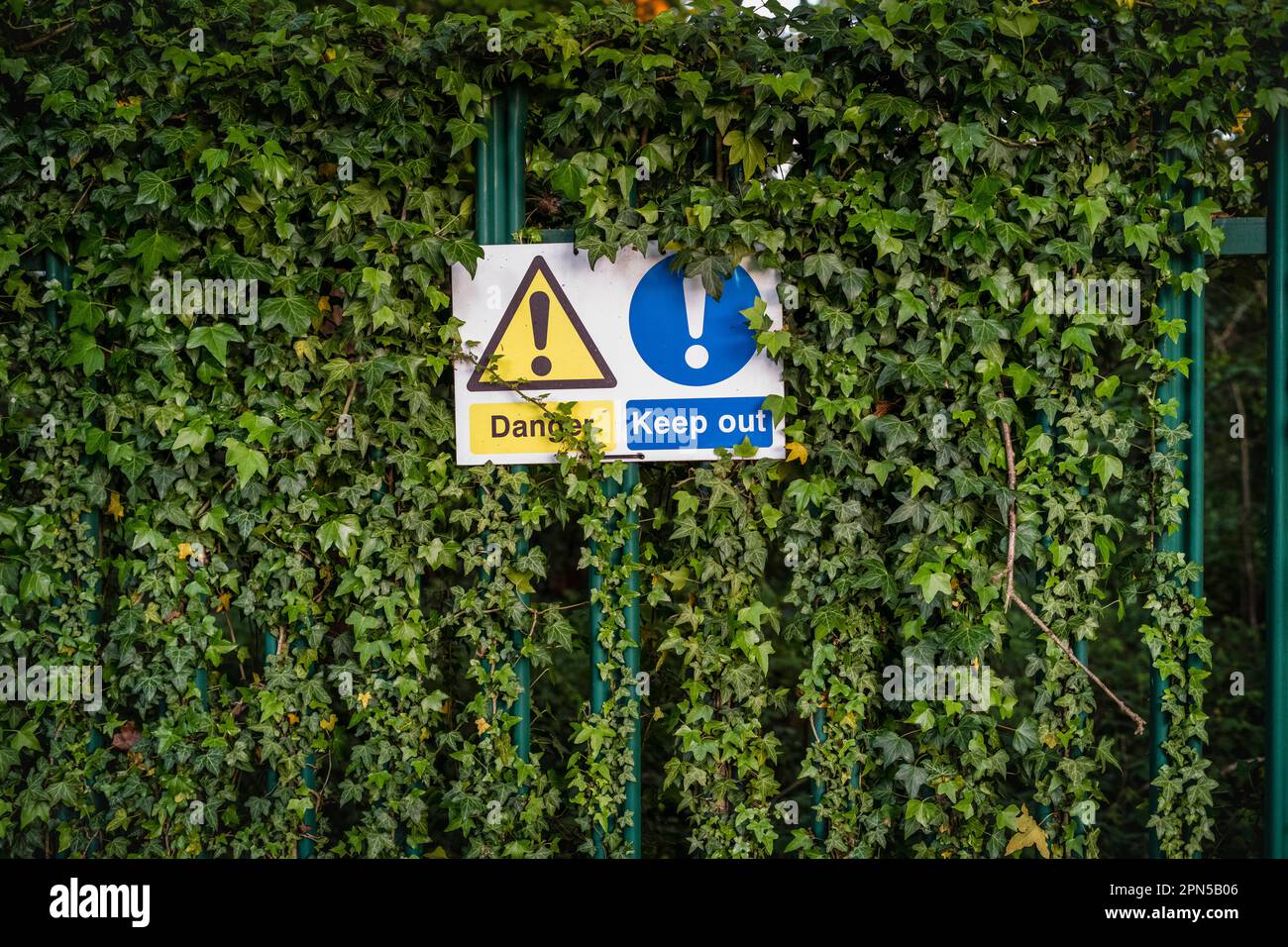 Signage being  obscured by greenery and foliage Stock Photo