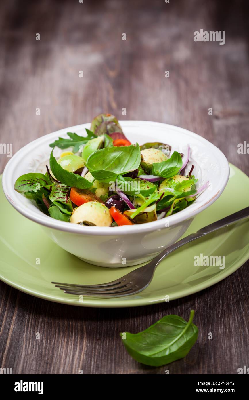 Spring mixed salad with avocado, olives and herbs Stock Photo