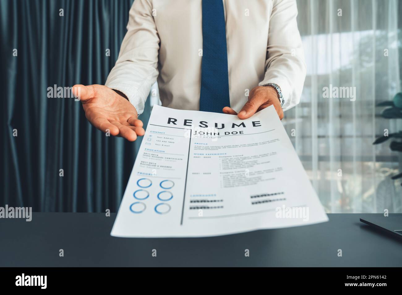 Confident Man Wearing Suit In Formal Office, Hand Holding Resume