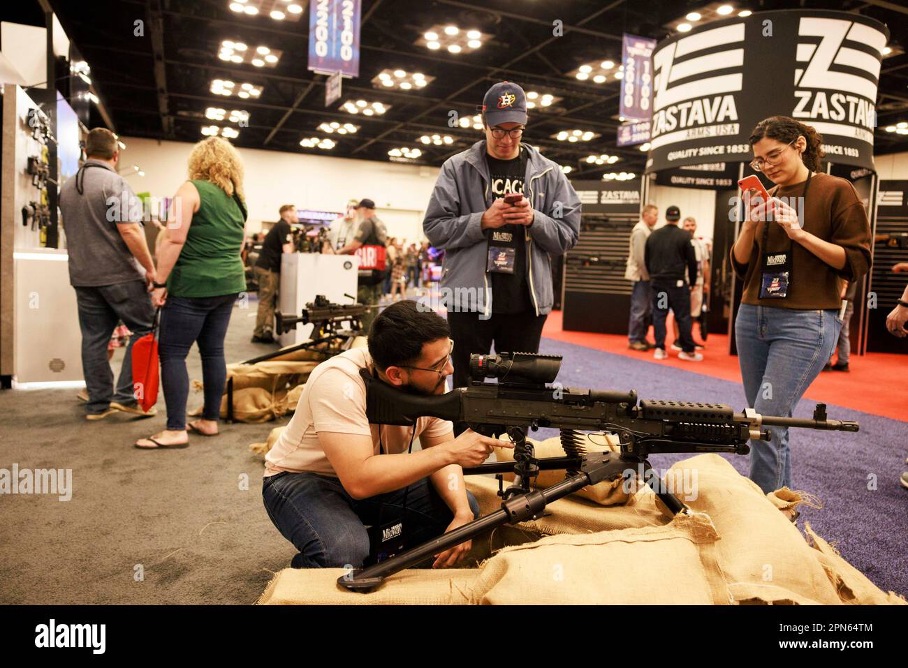 INDIANAPOLIS, INDIANA - APRIL 15: A guest looks through the sites of a machine gun at the at the Ohio Ordnance Works Inc., booth during the National Rifle Association's Annual Meetings & Exhibits at the Indiana Convention Center on April 15, 2023 in Indianapolis, Indiana. The convention, which is expected to draw around 70,000 guests opened Friday. (Photo by Jeremy Hogan/The Bloomingtonian) Stock Photo