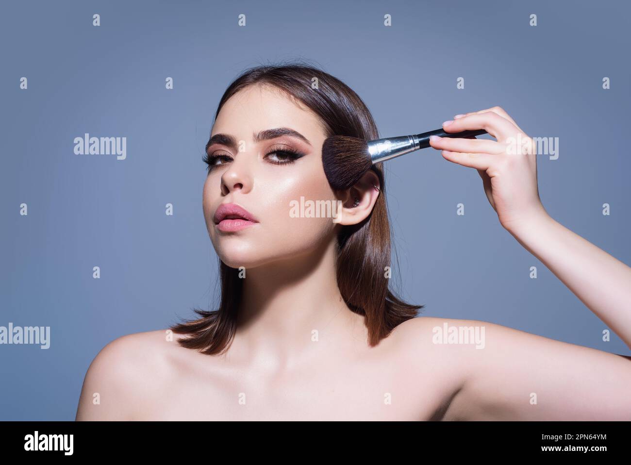 Girl hold blush blusher apply powder visage isolated over studio