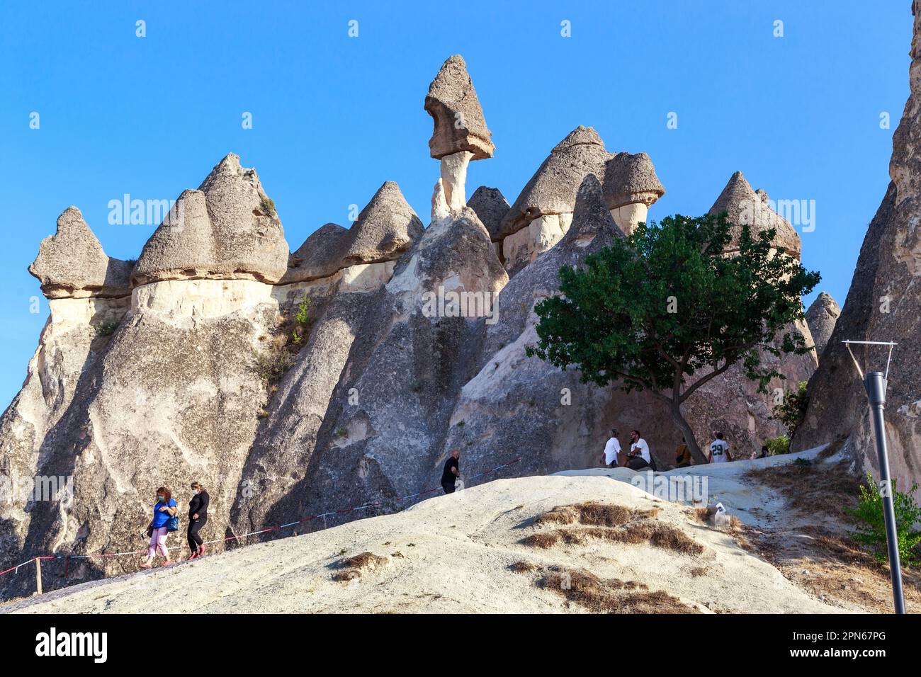 GOREME, TURKEY - OCTOBER 4, 2020: Undefined people inspect the fantastic cliffs in the Valley of the Monks (Pasaba Valley) in Cappadocia. Stock Photo
