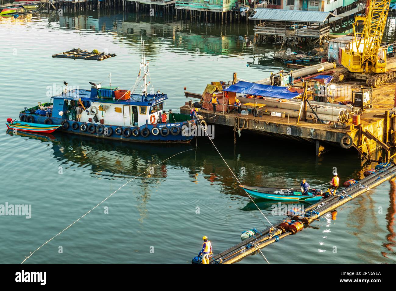 Engineering project over Mengkabong river while fishing boats continue
