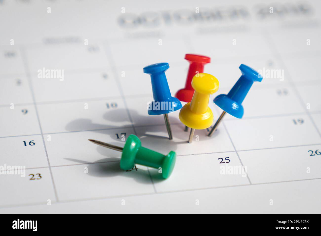 Multiple pins on one date on a calendar. Busy and fully booked schedule concept. Stock Photo
