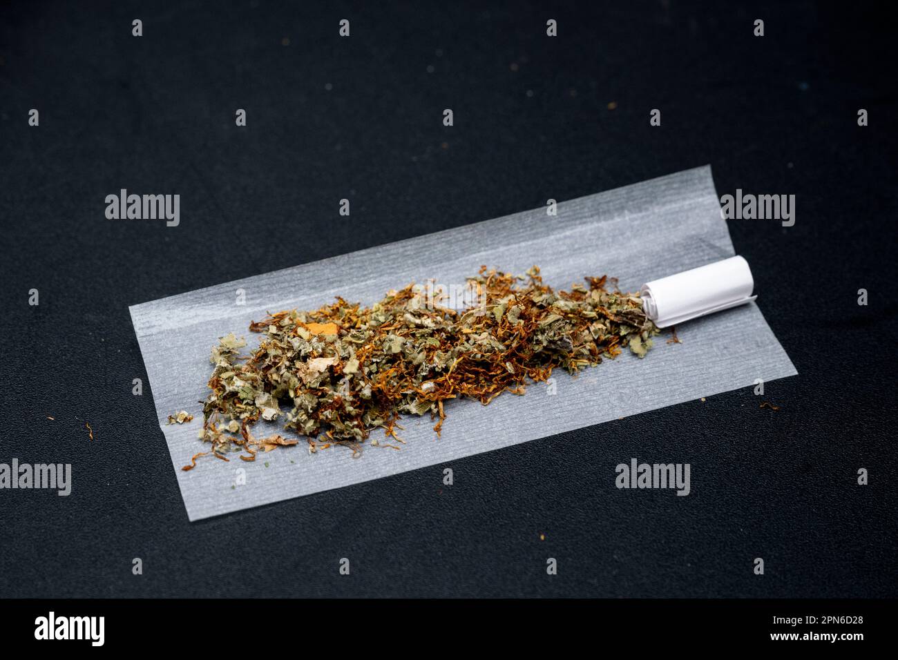 Berlin, Germany. 15th Apr, 2023. A mixture of tobacco and cannabis is  prepared for a joint. The concept of the traffic light coalition provides  that in Germany the possession of a maximum