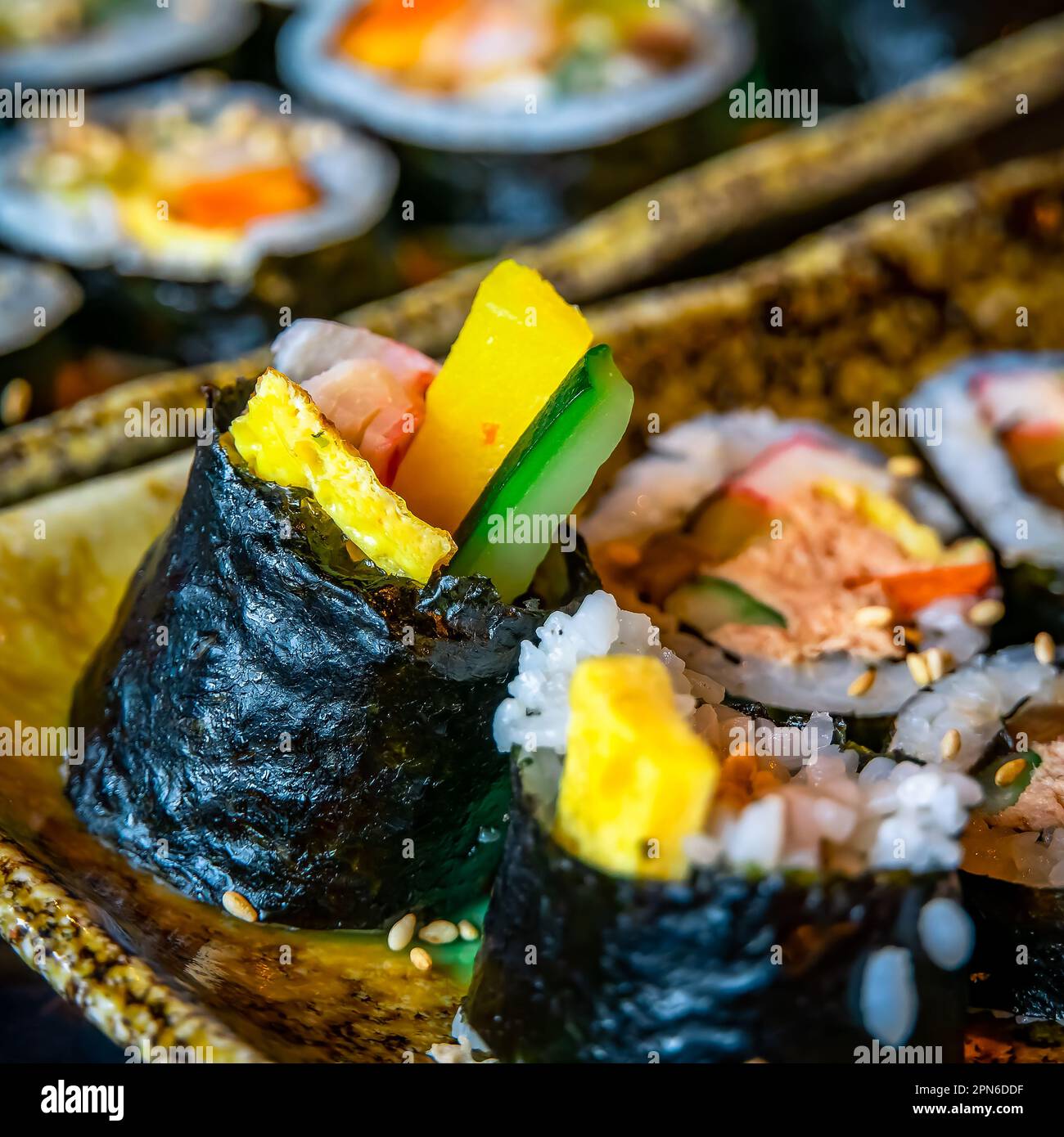 Gimbap is a Korean dish made from cooked rice and ingredients such as vegetables, fish, and meats that are rolled in gim (dried sheets of seaweed) and Stock Photo