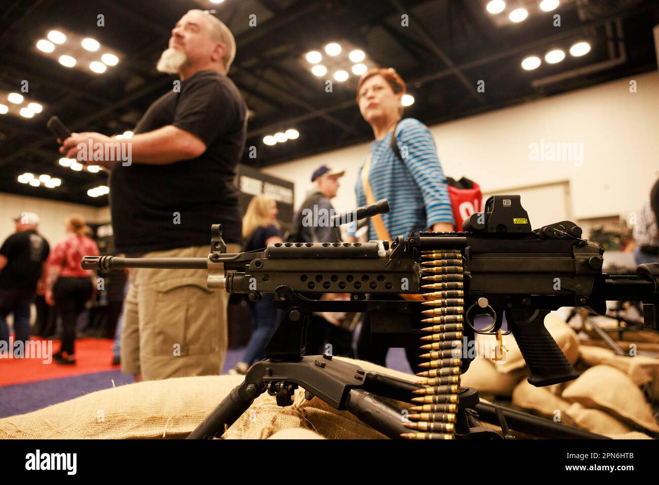 Indianapolis, United States. 16th Apr, 2023. Guests look at a machine gun at the Ohio Ordnance Works Inc., booth during the National Rifle Association's Annual Meetings & Exhibits at the Indiana Convention Center in Indianapolis. The convention, which is expected to draw around 70,000 guests opened Friday. Credit: SOPA Images Limited/Alamy Live News Stock Photo