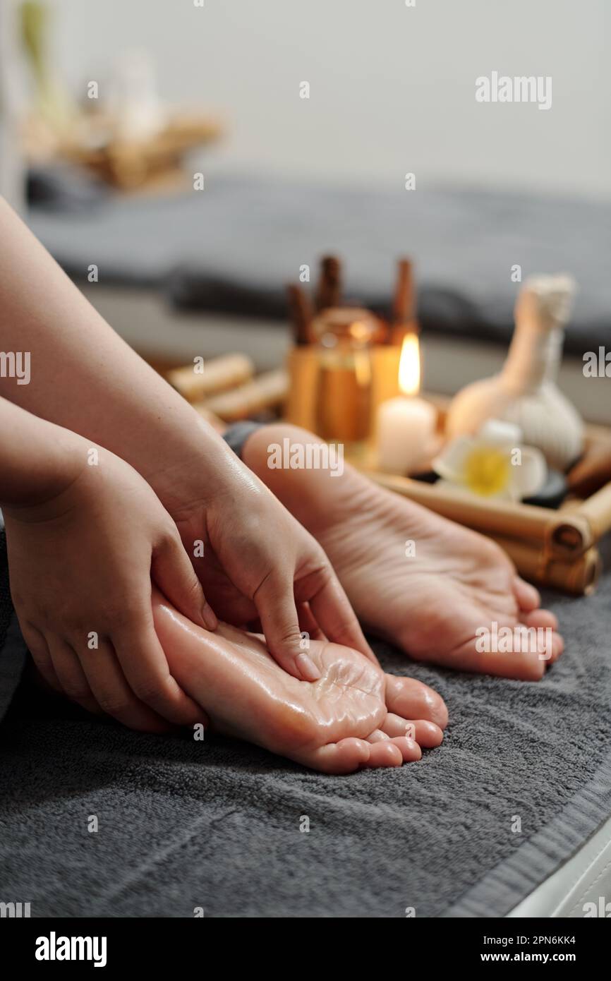 Therapist massaging feet of client with oils Stock Photo Alamy