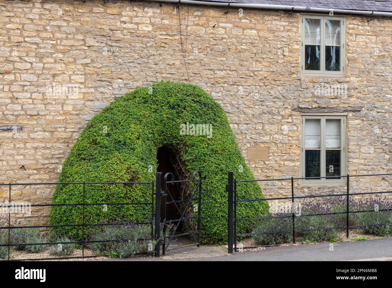 Stone built cottage with the entrance through a privet tunnel, Stoke Bruerne, Northamptonshire, England, UK Stock Photo