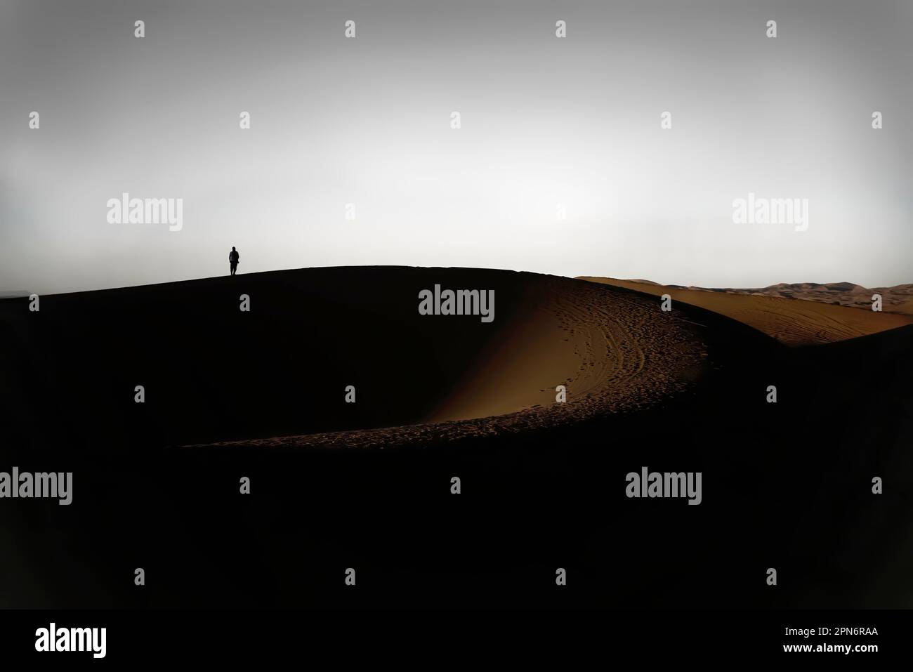 Arab man stands alone in the desert and watching the sunset. Stock Photo
