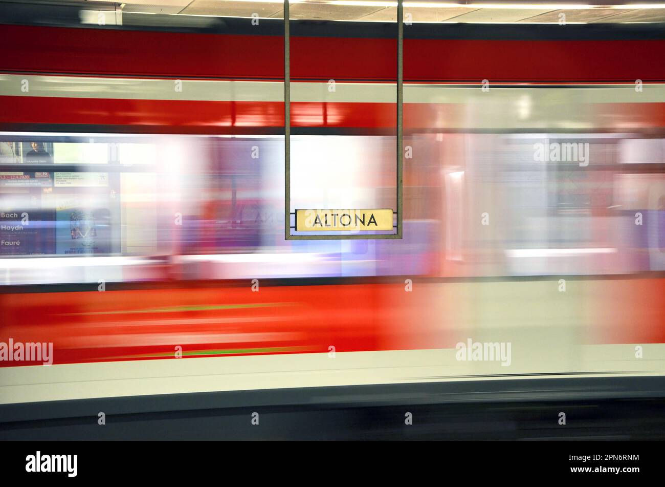 Altona station sign and passing by train behind it. Stock Photo