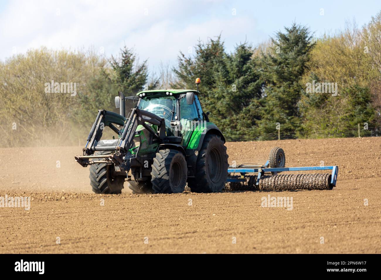 A tractor rolling the soil flat in a field in Scotland Stock Photo