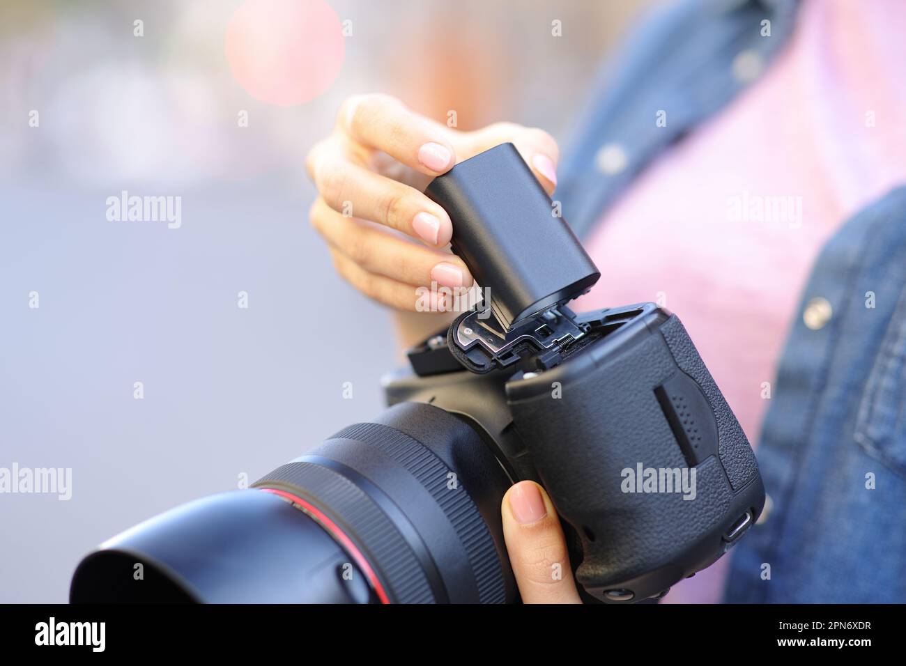 Close up portrait of a photographer changing battery on camera Stock Photo