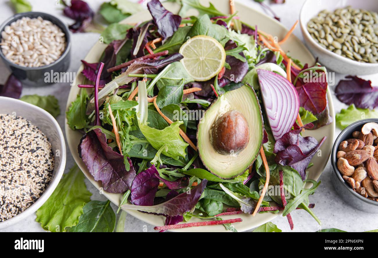 Salad of avocado and vegetables mixed greens lettuce leaves ready to eat. Stock Photo