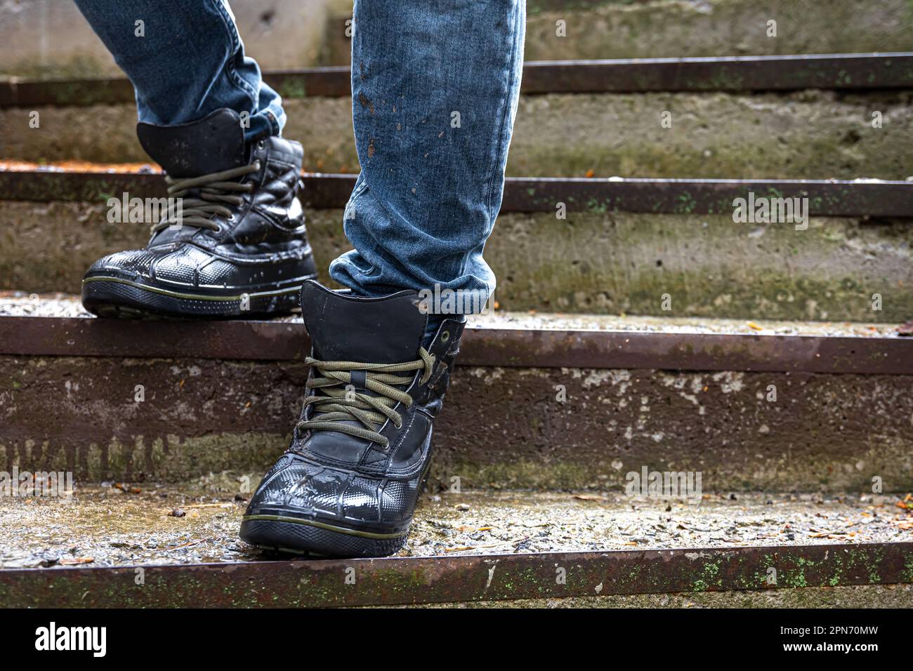 A man in boots on the old steps, close-up. Stock Photo