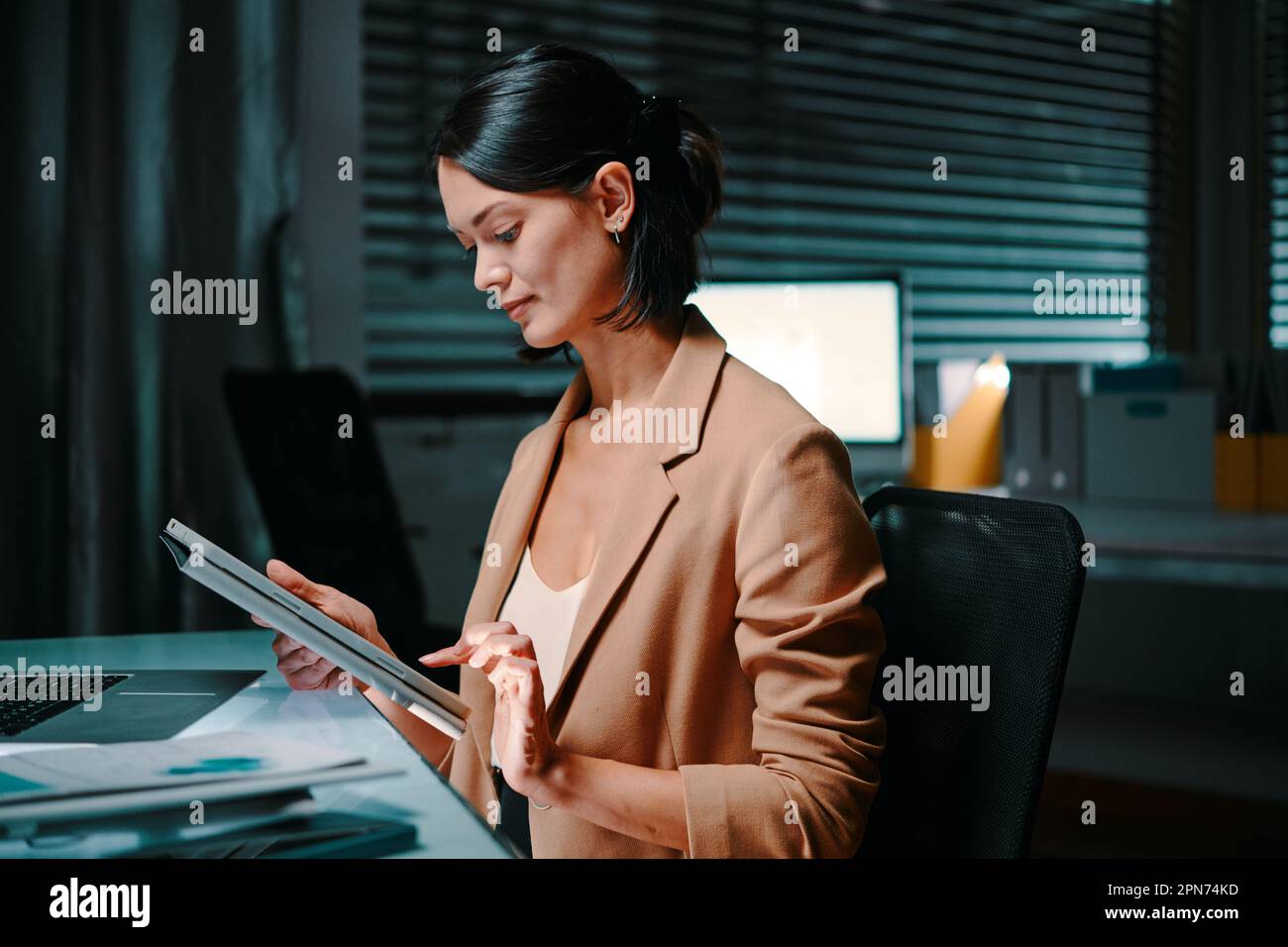 Young female entrepreneur reading report on digital tablet Stock Photo