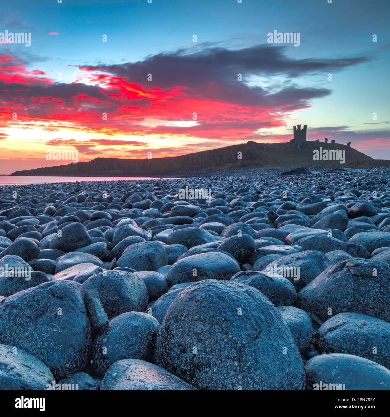Sunrise view of Dunstanburgh Castle looking south towards Craster in Northumberland, England, United Kingdom Stock Photo